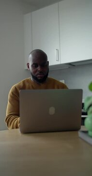 Man working on laptop in kitchen