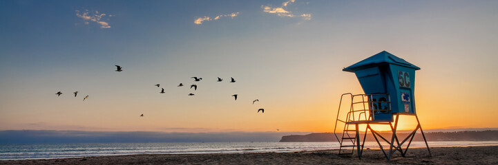 Lifeguard tower and seagulls on Coronado beach, panoramic sunset in San Diego, California - obrazy, fototapety, plakaty
