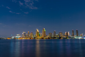 Fototapeta na wymiar San Diego skyline at night with water colorful reflections, view from Coronado island, California