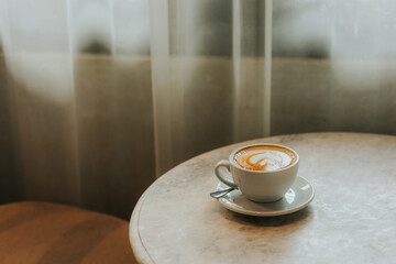Cup of latte on wooden table in cafe shop