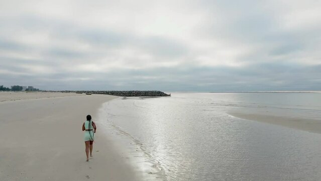 Woman running on the beach in cloudy morning on winter