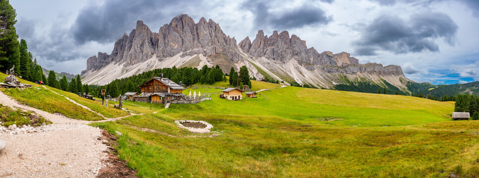 Dolomite landscape in Puez Odle Nature Park - view from alpine plateau with wooden houses and green meadows