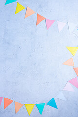 Colorful birthday party flags over cement concrete blue wall texture background