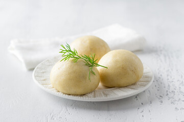 Freshly baked yeast-free steamed buns served with butter and herbs on a light blue background - 638447029