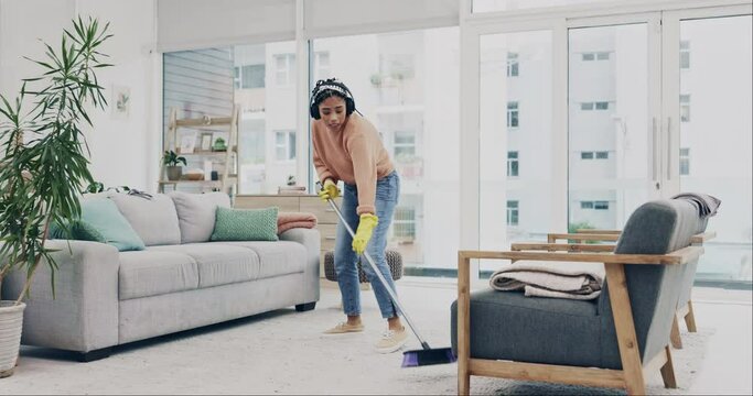 Cleaning, dance and broom with woman in living room for singer, housekeeping and streaming. Hygiene, dust and karaoke with cleaner listening to headphones at home for sweeping, music and energy