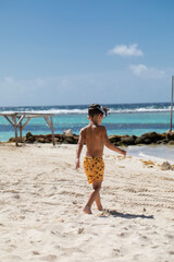 Beautiful little boy walking on a beach