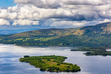 Naklejka na ściany i meble Beautiful Scottish Loch (Lake) with islands surrounded by mountains and a dramatic sky (Loch Lomond)
