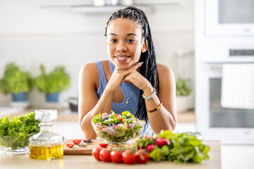 A good looking afro american girl prepared a healthy mixed salad of fresh vegetables