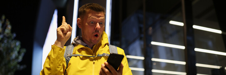 Inspired tourist looks at screen of his smartphone and finds solution to his problem.