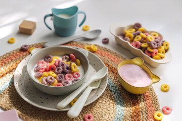 Colorful cereal rings with milk in bowl. Dry children's breakfast. Cute children's plates and bowls...