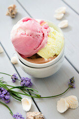 A variety of balls of ice cream in cones with chocolate, vanilla and strawberries