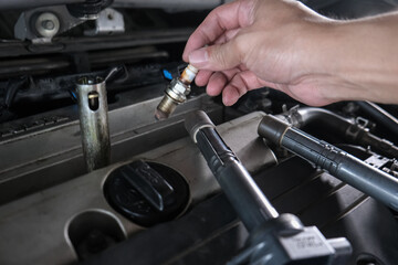 Mechanic man hand repair ignition on car engine