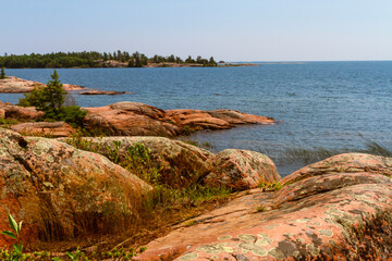 Shoreline along lake Huron. Granite Red rocks at the mouth of the Chikanishing Creek. Georgian Bay. Killarney Provincial Park, Ontario, Canada