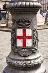 Genoa's coat of arms on a metal lamp post in the city 