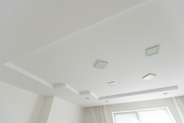 Stretched white matte ceiling in the room close-up