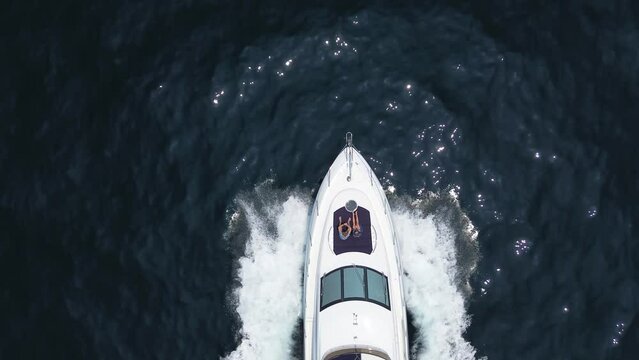Couple on honeymoon enjoying a trip on a private yacht, a couple on board a private motor yacht enjoying a trip by the sea, top down view