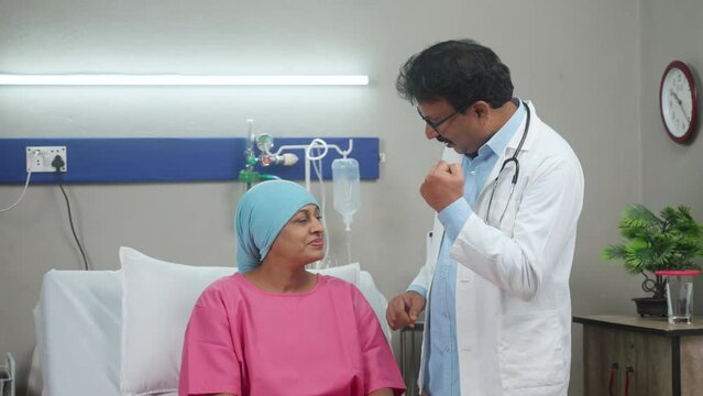 Indian senior doctor consoling or encouraging woman cancer patient by giving confidence at hospital - concept of Emotional Support, Medical Empathy and Empathy.