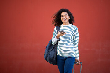 smiling young travel woman with suitcase and mobile phone