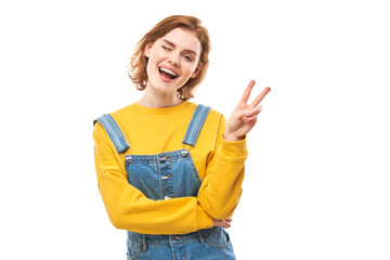 Portrait of young happy redhead woman in yellow casual showing peace and love gesture with fingers...