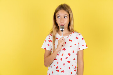 Very hungry Beautiful teen girl holding spoon into mouth dream of tasty meal