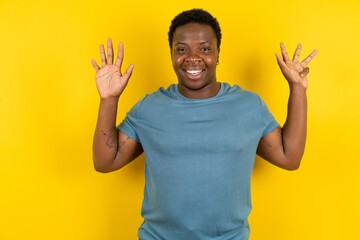 MODEL showing and pointing up with fingers number nine while smiling confident and happy.