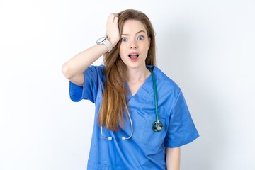 Embarrassed young beautiful doctor woman with shocked expression, expresses great amazement,...