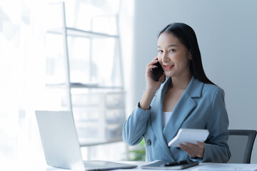 Shot of a beautiful young financial assistant sitting in front of laptop and fill the form in the office.