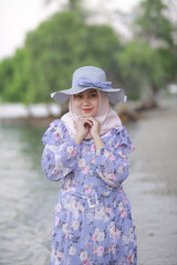 A young Hijab girl wearing beach hat is relaxing on the beach, Indonesia