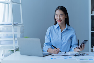 Shot of a beautiful young financial assistant sitting in front of laptop and fill the form in the office.