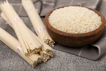 Funchoza.Dried raw rice noodles and rice on a textured background.Noodles with rice flour. Diet...