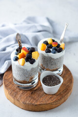 Vegetarian chia pudding with yogurt and fruits in jar on wooden serving board. - 638486253