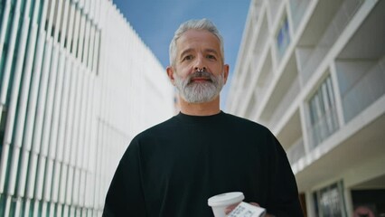 Elderly man looking camera on street closeup. Smiling bearded senior drinking - Powered by Adobe