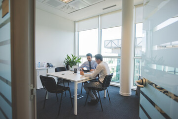 Fototapeta premium Two multiethnic millennials businessmen using computer working together