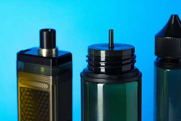 Black electronic cigarettes liquid bottles on blue background
