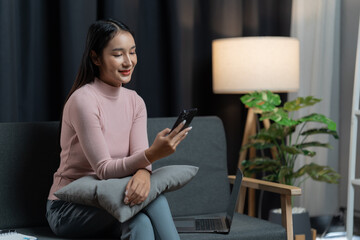 Obraz premium beautiful lady using laptop on the couch of her house.