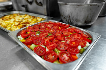 Stainless steel food trays on counter in professional kitchen