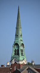 Fototapeta na wymiar tall church steeple detail in burlington, vermont (tower, window, blue sky) historic downtown small city united states, usa, vt, roof, rooftops, buildings, architecture, classical