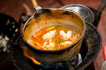 Cooking squid with red curry at a street food stall in Bangkok, Thailand.