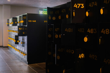 Square lockers, with open door, to store objects during the visit.