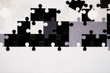 Black and white pieces of a puzzle, hanging on the wall, decorative.