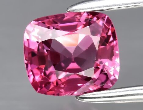Natural gemstone pink spinel on gray background