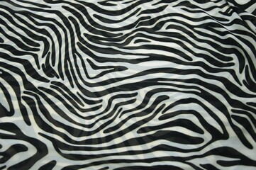 Animalistic abstract background of black and white stripes. A fragment of a pattern on a fabric as a background texture.