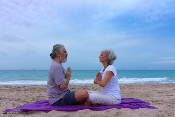 Woman and man meditating together sitting facing each other in prayer pose, promoting good personal relationship
