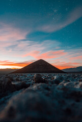 sunset in the high lands in argentina, salar de arizaro and the cono de arita, the most hight and perfect natural pyramid in the world, with the sky full of stars and the galaxy at sight