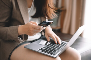 Asian woman holding credit card and using laptop computer for shopping online in website at home, e-commerce, internet banking, Technology and money transfer. Shopping and online payment concept.