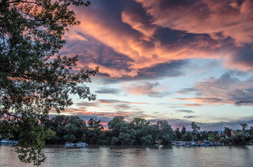 Sunset pink clouds on the river Danube. Summer landscape photo