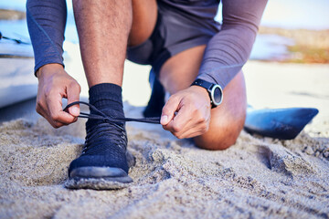 Hands tie shoes, ocean and athlete start workout, training and kayak exercise outdoor. Sand, person and tying sneakers at beach to prepare for fitness, sports and healthy body for wellness in summer.