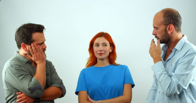 A group of coworkers, a woman and two men, are in a studio, looking at the camera. The woman suddenly farts, and the men make disgusted facial expressions and move away from her. 