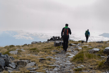 hikers walking next to low clouds in Sierra Nevada