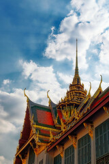 Fototapeta na wymiar Against a backdrop of clear blue sky, an exquisite Thai temple with a towering spire embodies the splendor of Asian architecture.